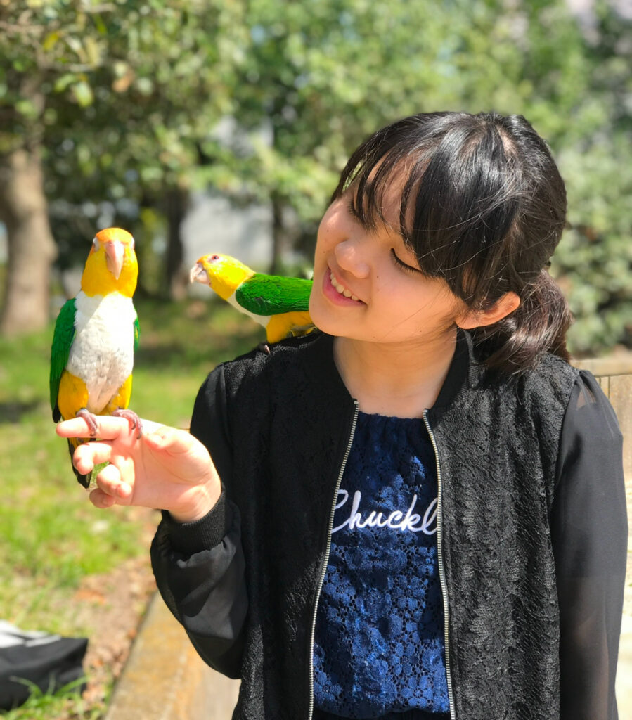 インコと遊ぶ笑顔の女性